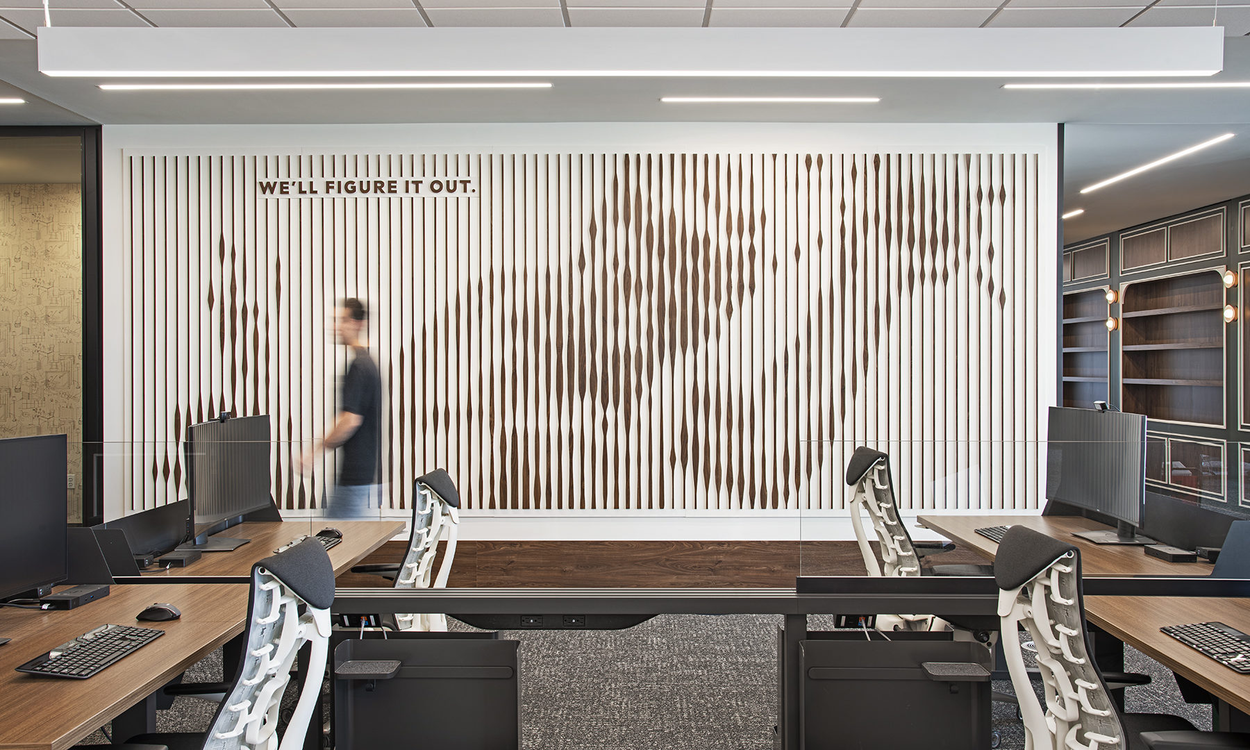 Modern corporate office meeting room with wood slat accent wall and glass conference table in Detroit