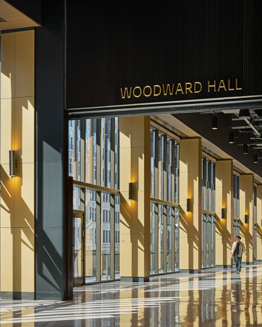 Modern commercial interior hallway with illuminated Woodward Hall signage and floor-to-ceiling windows in Detroit