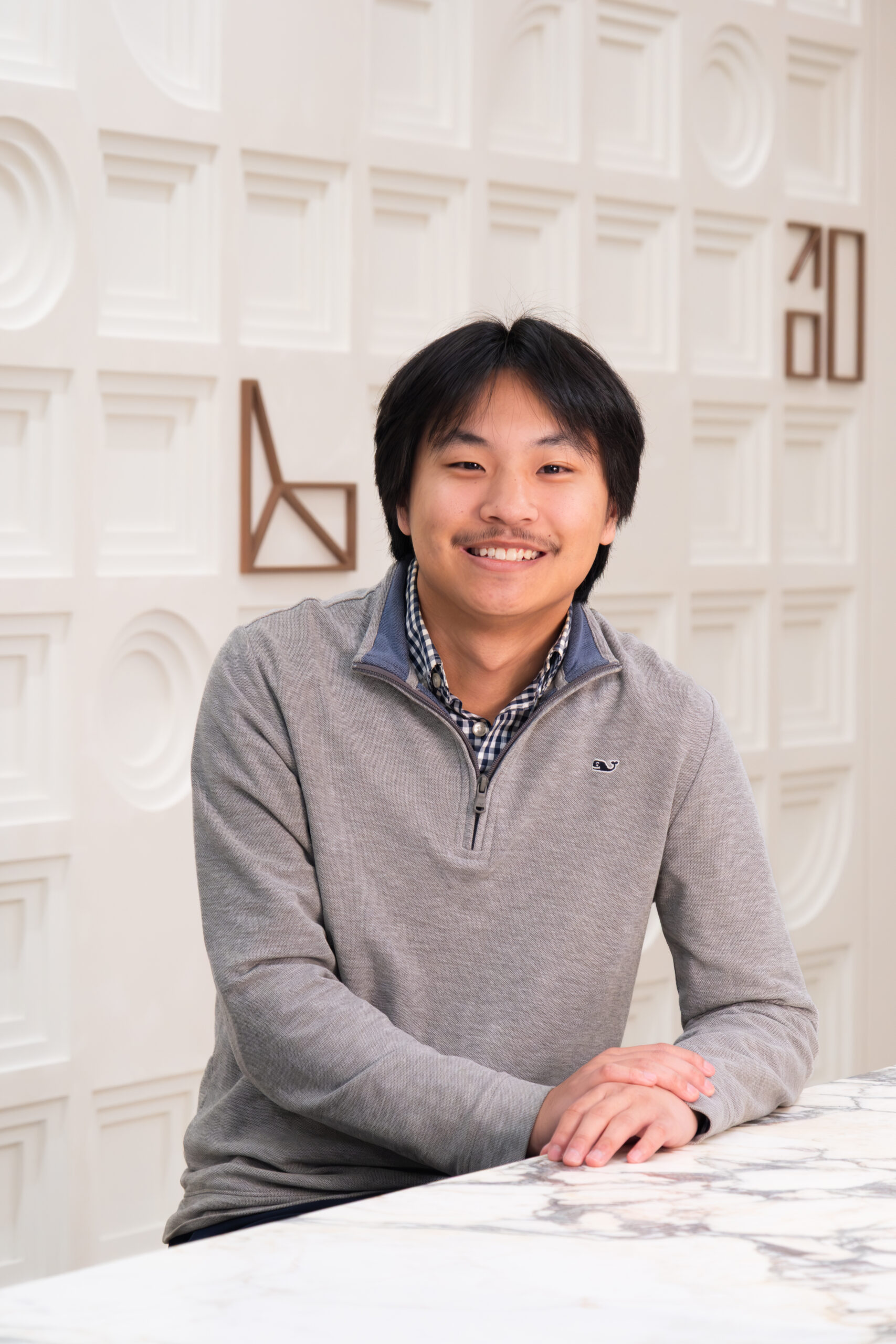 male interior designer smiling at modern office desk in Detroit commercial design studio